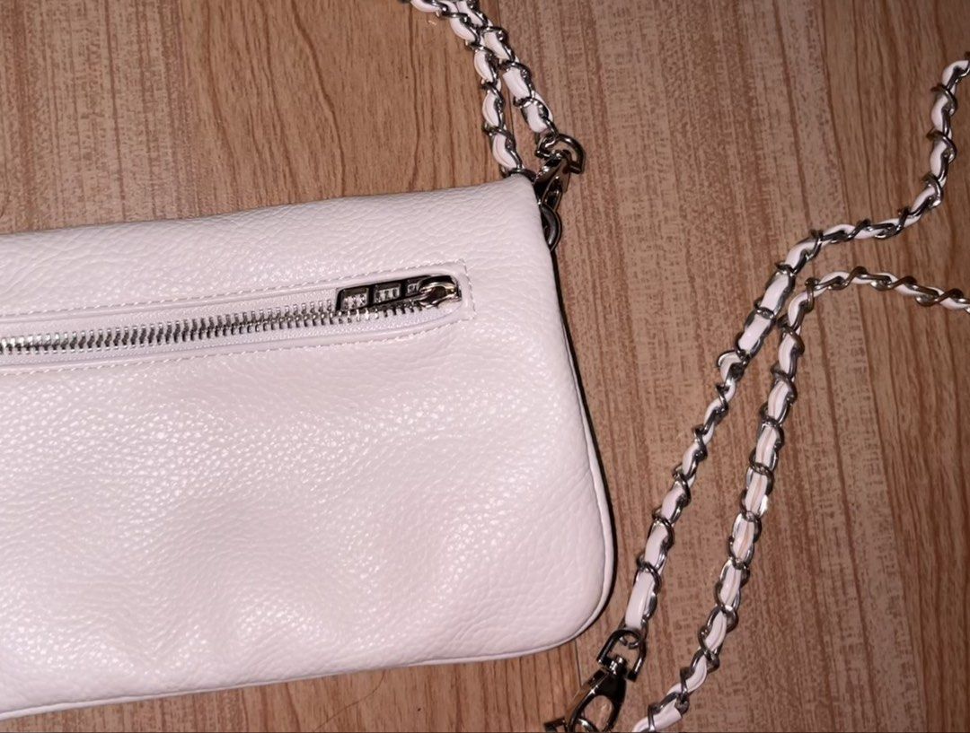 Zadig & Voltaire White Leather Rock Clutch (Category: Cross-body Bags) located in Manila. Submitted by angelinama02203 (Listing ID 1467125253, Image 2). Description: - Brand: Zadig & Voltaire - Material: White pebbled leather with silver hardware - Design: Signature crystal-embellished winged front flap - Straps: Removable woven chain and leather strap - Storage: Front zipper pocket and back zip compartment - Condition: Clean interior and exterio