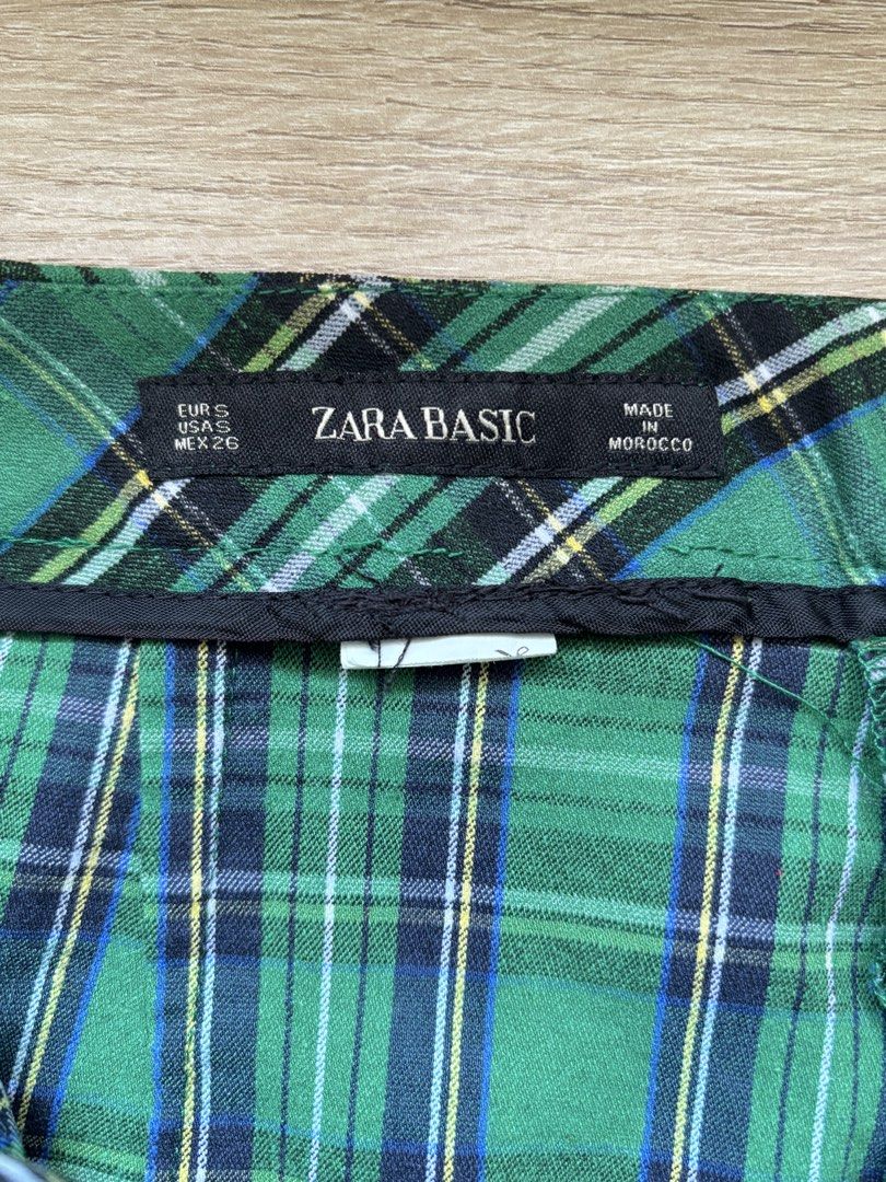 Zara Basic Green Plaid Tartan Mini Skirt Size S (Category: Skirts) located in Paranaque City. Submitted by ggg.bin (Listing ID 1466975980, Image 3). Description: - Brand: Zara Basic - Style: Green tartan plaid mini skirt - Color: Green, blue, and black checkered pattern - Size: S / US S / MEX 26 - Origin: Made in Morocco - Condition: Clean inside and out - Details: Features a chic waistband, perfect for layering with sweaters and boots.