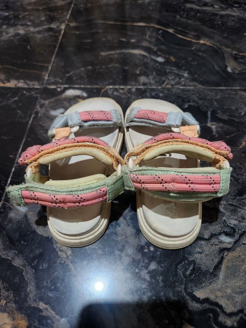 Zara Kids Multicolor Strap Sandals Size 15cm (Category: Babies & Kids Fashion) located in Santo Tomas. Submitted by anneiyayey (Listing ID 1467000642, Image 2). Description: - Brand: Zara Kids - Design: Multi-color pastel straps (pink, light blue, yellow, green) - Size: Around 15cm sole length - Closure: Adjustable hook and loop for easy wear - Condition: Great casual footwear with light wear on bottom treads.