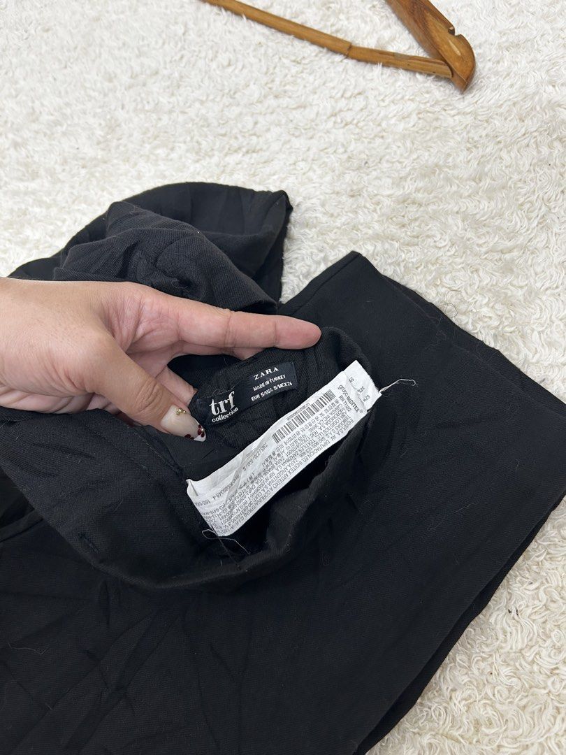 Zara TRF Collection Black Trousers (Category: Jeans) located in Valencia. Submitted by crizzagella20 (Listing ID 1467158029, Image 3). Description: - Brand: Zara TRF Collection - Color: Classic Black - Size: S (Made in Turkey) - Fit & Style: High-waisted with chic front pleats - Comfort: Elastic back waistband with secure button closure - Measurements: Waist 27-30 inches, Length 39 inches - Condition: Excellent, fabric care tags intact.