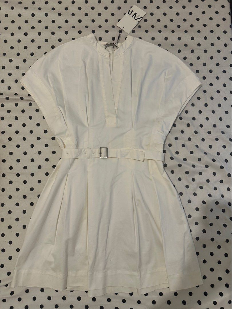 Zara White Belted Mini Dress (Category: Dresses) located in San Pedro. Submitted by sweetcosmics (Listing ID 1467072082, Image 3). Description: - Brand: Zara - Condition: Brand new with tag attached - Size: XS-Medium - Style: Mini dress with short sleeves, mandarin collar, and deep V-neckline - Details: Pleated skirt section and matching fabric belt with silver buckle -RFS: Bought for an event, never worn & comes with the original tag. Selling fo