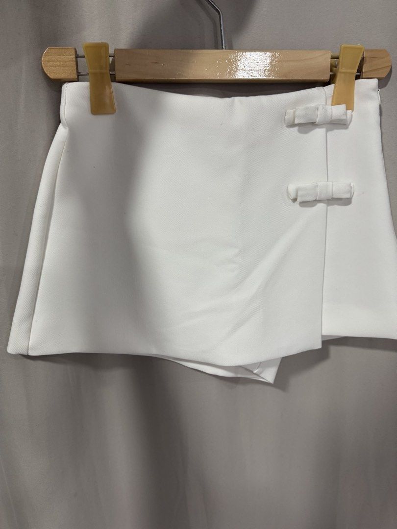 Zara White Bow Skort Size XS (Category: Skirts) located in Manila. Submitted by decluterthings888 (Listing ID 1467168123, Image 2). Description: - Brand: Zara - Item: White skort - Size: XS (EUR XS, USA XS, MEX 24) - Made in Turkey - Design: Wrap-around style with two cute decorative bows on the front - Condition: Clean and ready to wear.