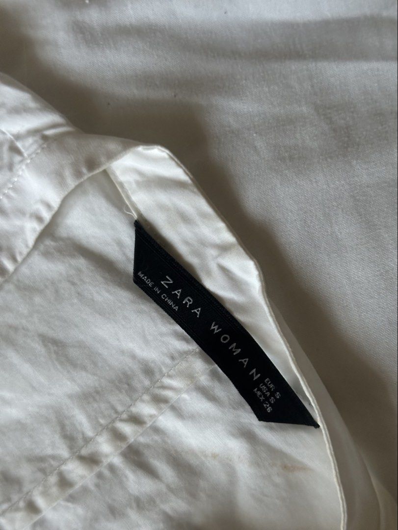 Zara White Ruched Front Puff Sleeve Blouse (Category: Blouses) located in Paranaque City. Submitted by rishyscloset (Listing ID 1467098267, Image 2). Description: Brand: Zara * Color: White * Style: Deep V-neck with ruched front twist detail * Sleeves: Short puff sleeves with subtle gathers * Closure: Side zipper * Material: Lightweight cotton or cotton blend (unconfirmed) * Condition: Good; needs a quick iron due to storage. Never used!.