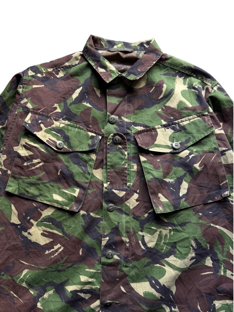 1990's British Army DPM Combat Lightweight Jacket (Category: Coats, Jackets and Outerwear) located in Pasig City. Submitted by hoardwrld (Listing ID 1467180066, Image 2). Description: Width: 23.5 Length: 31.5 - Authentic British military field shirt in classic DPM woodland camouflage - Heavy-duty, durable cotton fabric built for rugged wear - Button-down front featuring dual chest cargo pockets - Distinct rank tab on the chest placket and sturdy 