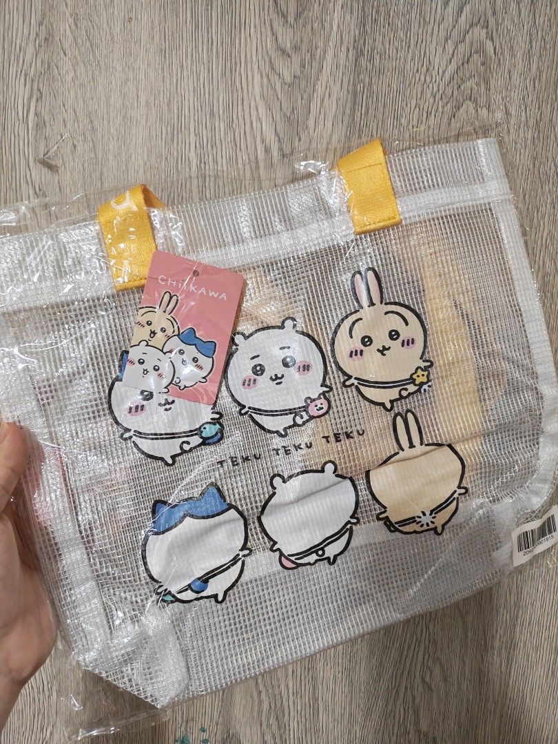 2 Chiikawa Clear Mesh Tote Bags (Category: Tote Bags) located in Manila. Submitted by declutter_sarah (Listing ID 1467321081, Image 3). Description: - Authentic Chiikawa clear mesh tote bag with cute character prints - Brand new, sealed in original plastic packaging - Features stylish branded straps reading "CHIIKAWA" - Two handle color options available: Pink or Yellow - Spacious and sturdy, perfect for daily essentials or convention shopping.