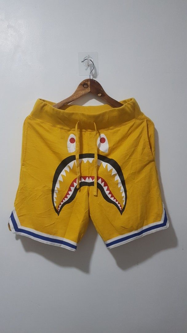 A Bathing Ape Shark Yellow Shorts (Category: Shorts) located in Manila. Submitted by nice430 (Listing ID 1467296592, Image 1). Description: - Brand: BAPE (A Bathing Ape) - Item: Shark Shorts - Color: Yellow with blue and white accents - Size: Small (S) - Material: 90% cotton, 10% nylon - Features: Iconic shark face graphic, adjustable drawstring waistband, striped leg trim - Origin: Made in China - Condition: Brand new / Excellent quality streetw