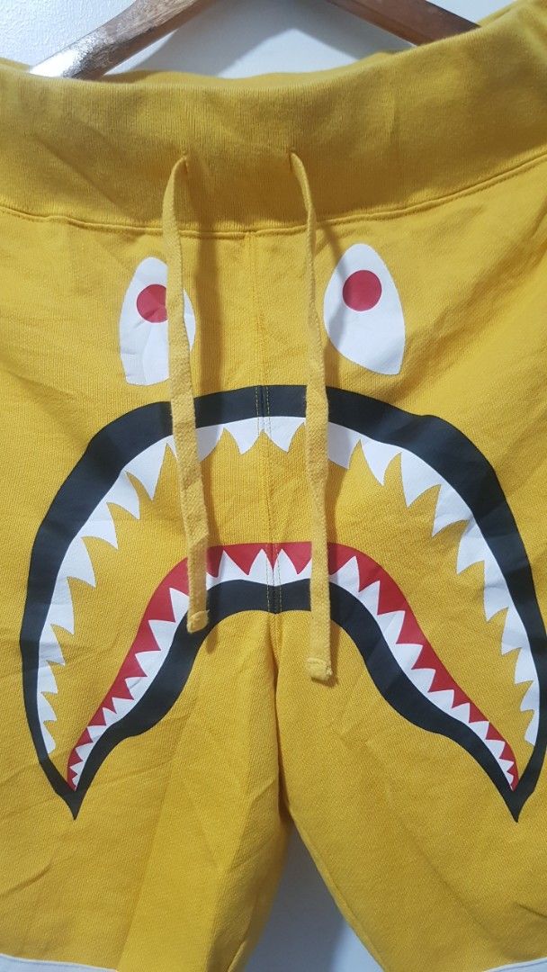 A Bathing Ape Shark Yellow Shorts (Category: Shorts) located in Manila. Submitted by nice430 (Listing ID 1467296592, Image 2). Description: - Brand: BAPE (A Bathing Ape) - Item: Shark Shorts - Color: Yellow with blue and white accents - Size: Small (S) - Material: 90% cotton, 10% nylon - Features: Iconic shark face graphic, adjustable drawstring waistband, striped leg trim - Origin: Made in China - Condition: Brand new / Excellent quality streetw