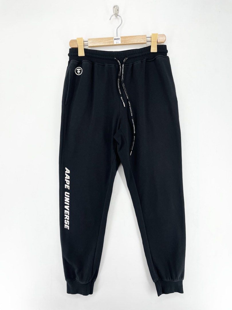 AAPE Black Universe Jogger Pants (Category: Joggers) located in Manila. Submitted by buzz.garments (Listing ID 1467352597, Image 1). Description: Size: Large on tag Dimensions(inches) -Waist/Width: 30”-40” (Strechable) -Hip: 20” -Front Rise: 13” -Thigh: 12” -Inseam: 27” -Outseam/Length : 37” -Leg Opening: 5” - color may vary due to lighting. please manage your expectations-minimal and unseen flaws must be considered..