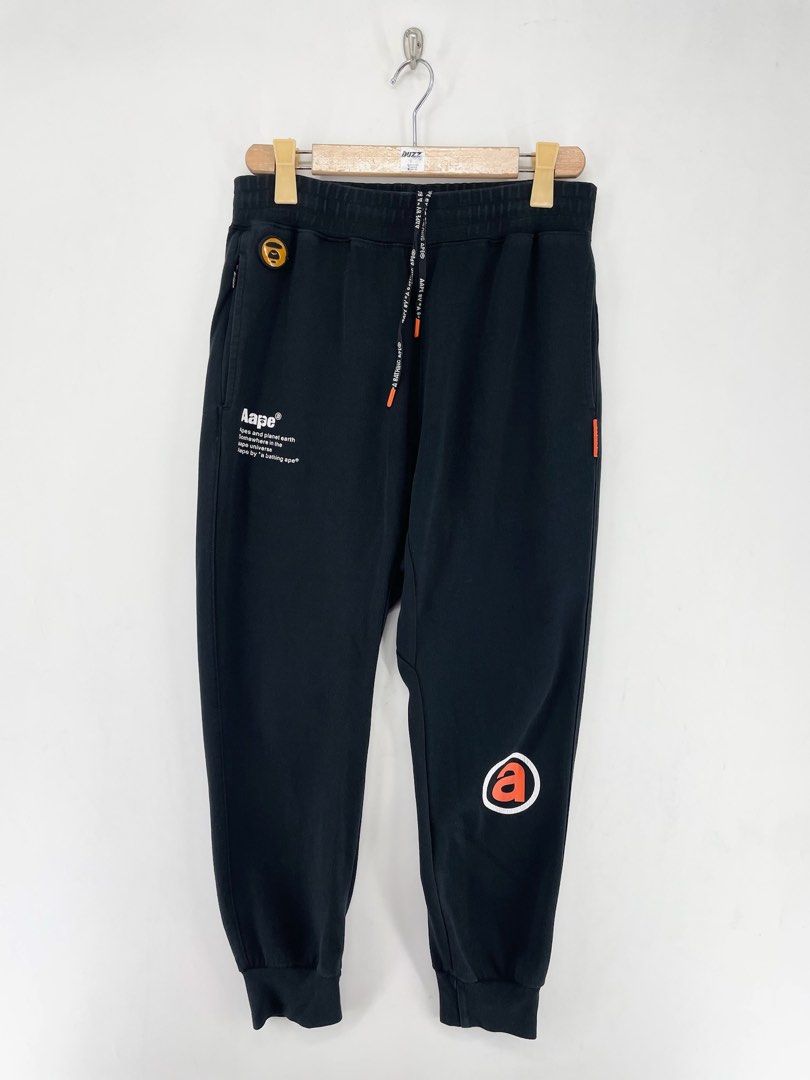 AAPE Orange Logo Jogger Pants (Category: Joggers) located in Manila. Submitted by buzz.garments (Listing ID 1467353040, Image 1). Description: Size: Medium on tag Dimensions(inches) -Waist/Width: 30”-40” (Strechable) -Hip: 22” -Front Rise: 15” -Thigh: 12” -Inseam: 25” -Outseam/Length : 36” -Leg Opening: 4” minor hairlines - color may vary due to lighting. please manage your expectations-minimal and unseen flaws must be considered..