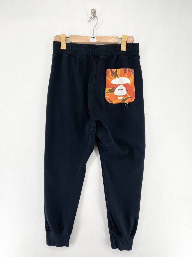 AAPE Orange Logo Jogger Pants (Category: Joggers) located in Manila. Submitted by buzz.garments (Listing ID 1467353040, Image 2). Description: Size: Medium on tag Dimensions(inches) -Waist/Width: 30”-40” (Strechable) -Hip: 22” -Front Rise: 15” -Thigh: 12” -Inseam: 25” -Outseam/Length : 36” -Leg Opening: 4” minor hairlines - color may vary due to lighting. please manage your expectations-minimal and unseen flaws must be considered..