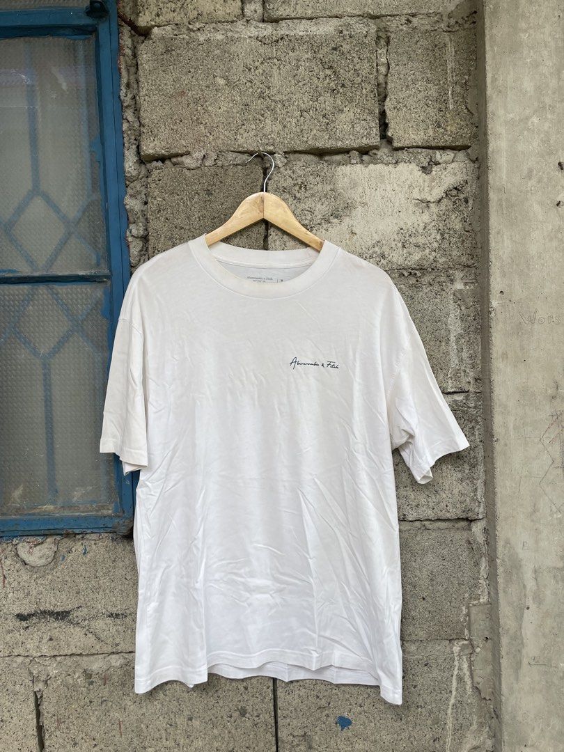 Abercrombie & Fitch Oversized Soft A&F Tee White Medium (Category: Tshirts & Polo Shirts ) located in Dagupan City. Submitted by thriftykiddo.ph (Listing ID 1467227481, Image 1). Description: - Brand: Abercrombie & Fitch - Color: White - Size: Medium (Oversized fit) - Material: Soft A&F signature tee fabric - Details: Small embroidered script logo on left chest, large bold block lettering graphic print on the back - Neckline/Sleeves: Crew necklin