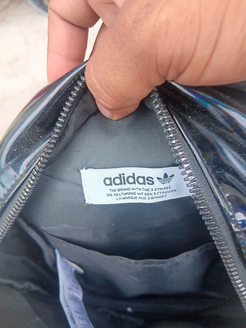 Adidas 3 Stripes Iridescent Mini Backpack Black (Category: Backpacks) located in Cagayan de Oro. Submitted by kokirts17 (Listing ID 1467209710, Image 3). Description: - Color/Finish: Black iridescent with embossed 3 Stripes lettering - Hardware: Matching trefoil zipper puller - Straps: Adjustable shoulder straps with buckles - Compartments: Main zipped compartment, front zipped pocket, and interior open slip pocket - Details: Features Adidas bran