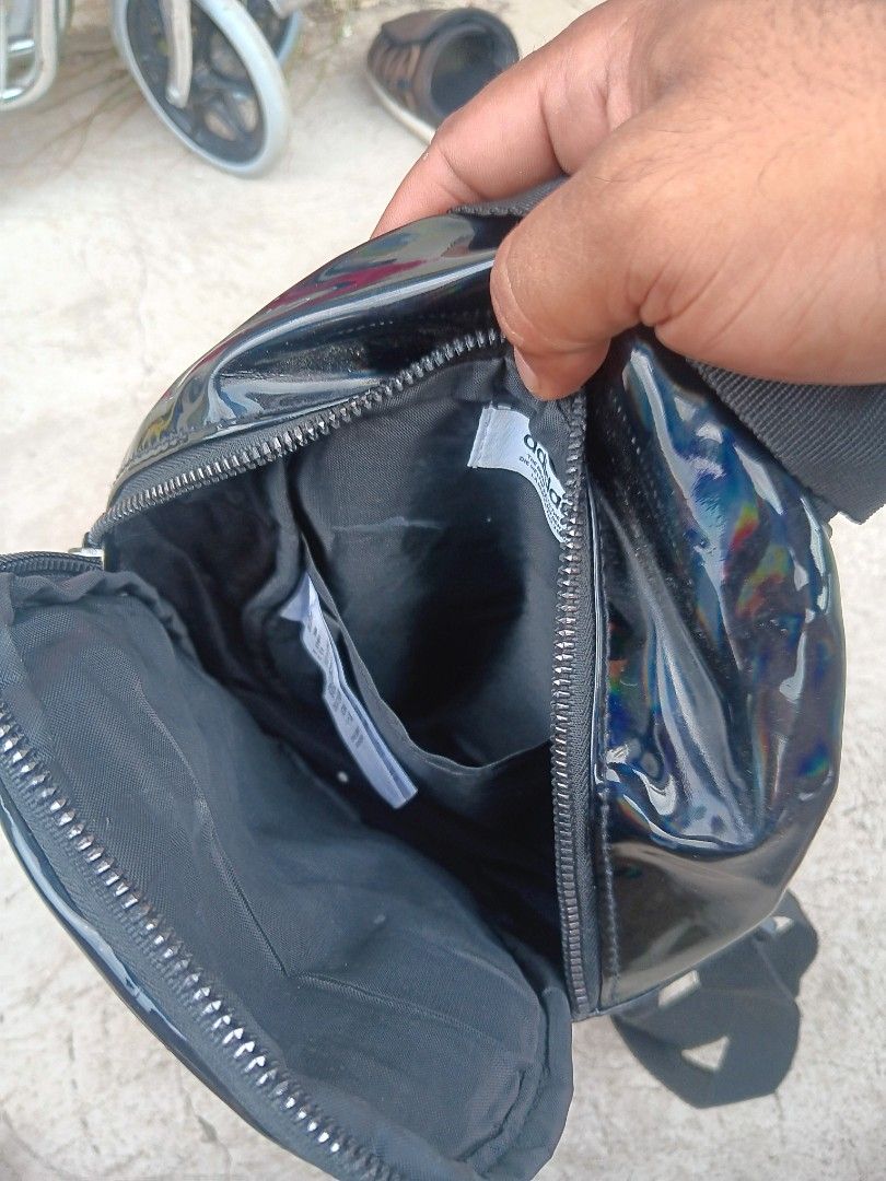 Adidas 3 Stripes Iridescent Mini Backpack Black (Category: Backpacks) located in Cagayan de Oro. Submitted by kokirts17 (Listing ID 1467209710, Image 2). Description: - Color/Finish: Black iridescent with embossed 3 Stripes lettering - Hardware: Matching trefoil zipper puller - Straps: Adjustable shoulder straps with buckles - Compartments: Main zipped compartment, front zipped pocket, and interior open slip pocket - Details: Features Adidas bran