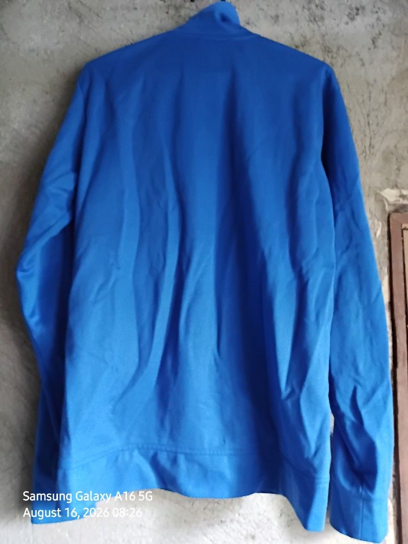 Adidas Blue Zip-up Jacket Size 105 (Category: Coats, Jackets and Outerwear) located in Manila. Submitted by thomyorke14 (Listing ID 1467249830, Image 3). Description: - Brand: Adidas - Color: Bright blue - Size: 105 (Made in Indonesia) - Style: Zip-up jacket with high neck collar and full zipper closure Dimes 20 by 27 - Details: Ribbed inner lining near the collar, classic trefoil logo branding - Condition/Use: Comfortable fabric, perfect for eve