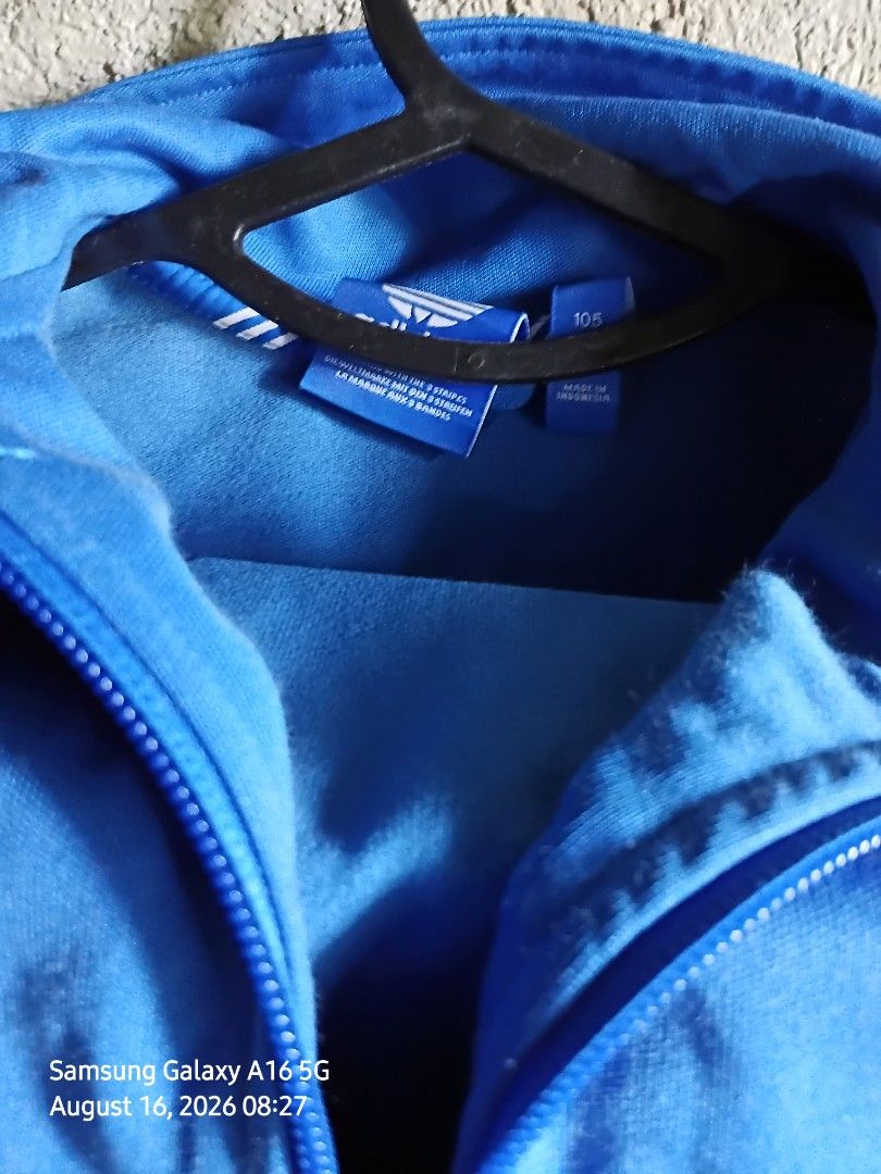Adidas Blue Zip-up Jacket Size 105 (Category: Coats, Jackets and Outerwear) located in Manila. Submitted by thomyorke14 (Listing ID 1467249830, Image 1). Description: - Brand: Adidas - Color: Bright blue - Size: 105 (Made in Indonesia) - Style: Zip-up jacket with high neck collar and full zipper closure Dimes 20 by 27 - Details: Ribbed inner lining near the collar, classic trefoil logo branding - Condition/Use: Comfortable fabric, perfect for eve
