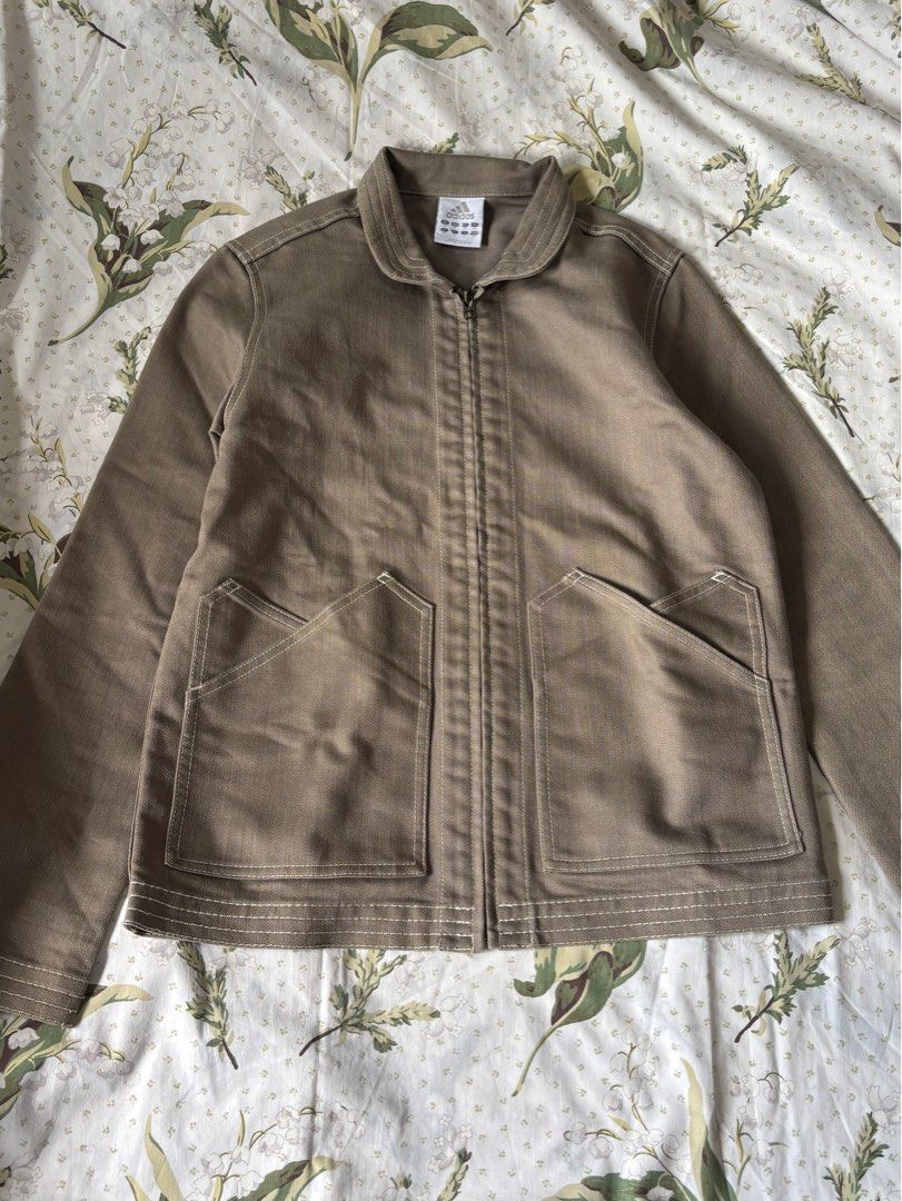 Adidas Brown Canvas Zip Jacket (Category: Coats, Jackets and Outerwear) located in Baguio. Submitted by crianzathrifts (Listing ID 1467331937, Image 1). Description: - Brand/Style: Adidas brown canvas zip-up jacket with a sturdy workwear vibe - Details: Contrast white stitching, classic collar, full front zipper, and two large front patch pockets - Branding: Subtle embroidered Adidas logo on the sleeve - Measurements: Approx. 15" across the chest