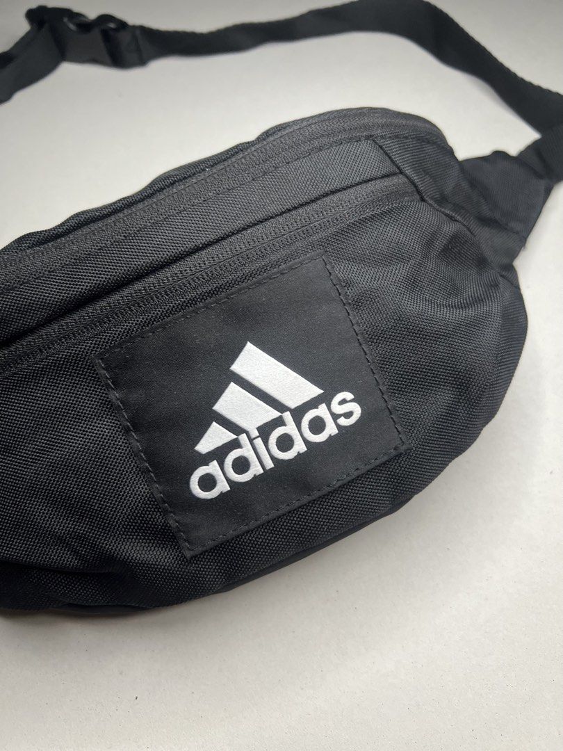 Adidas ESS Waist Bag Black (Category: Belt bags, Clutches and Pouches) located in Tacloban City. Submitted by thrftg (Listing ID 1467279772, Image 2). Description: - Authentic Adidas waist bag in classic black - Bold white Adidas logo patch on the front - Durable fabric built for everyday wear - Features a secure main compartment and handy front zip pocket - Adjustable strap with sturdy buckle closure - Ideal for daily errands, traveling, or gym 