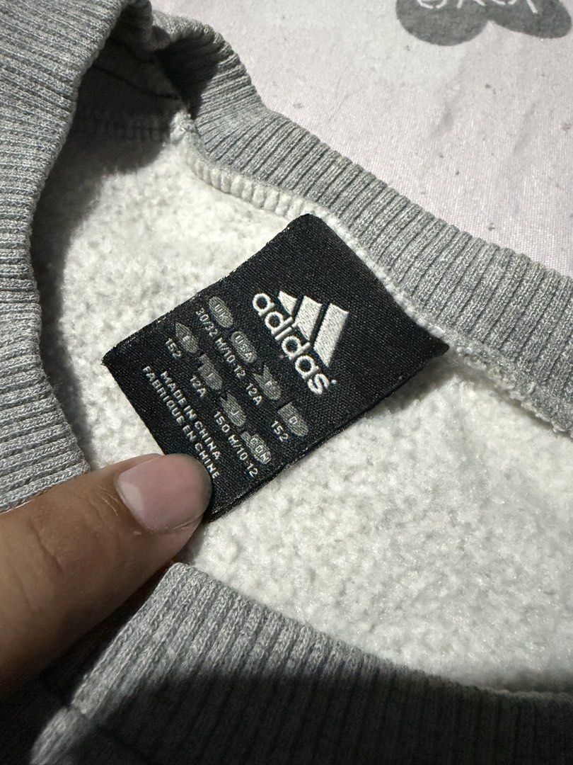 Adidas Grey Black Sweatshirt Size 10-12 / 152 (Category: Coats, Jackets and Outerwear) located in Manila. Submitted by mcllts (Listing ID 1467344147, Image 2). Description: - Brand: Adidas - Color: Grey with black and white side panels - Size: 10-12 years / 152 cm - Design: Classic crewneck, iconic front logo, and 3-stripes detailing on sleeves - Features: Ribbed cuffs and hem, made in China - Condition: Comfortably stylish casual wear for cooler