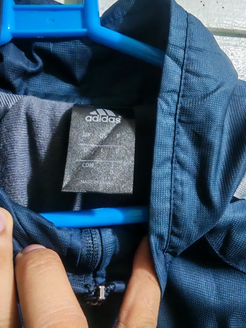 Adidas Navy Blue Track Jacket (Category: Coats, Jackets and Outerwear) located in Iriga City. Submitted by aldwinpawl (Listing ID 1467176324, Image 3). Description: - Brand: Adidas - Color: Dark blue with grey stripes - Material: 100% polyester (shell and lining) - Features: Full-zip front, stand-up collar, embroidered Adidas logo on right chest - Origin: Made in China - Condition: Clean, lightweight, and comfortable.