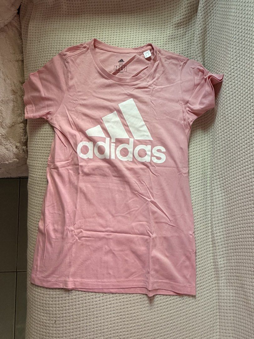 Adidas Pink T-shirt (Category: Shirts) located in Manila. Submitted by amilannnn (Listing ID 1467199083, Image 1). Description: - Brand: Adidas - Color: Pink with large white logo - Size: XS to S - Material: Comfortable, breathable cotton - Fit/Style: Short sleeves, crew neck, casual wear - Condition: Clean and well-maintained - Easy to pair with jeans or joggers.
