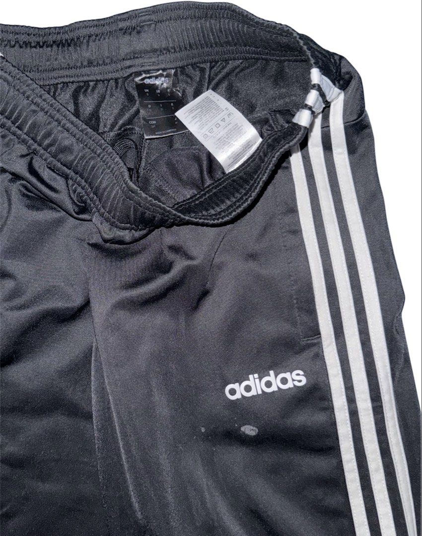 Adidas Track Pants Black White (Category: Joggers) located in San Narciso. Submitted by angels.attic21 (Listing ID 1467312208, Image 2). Description: - Brand: Adidas - Color: Black with classic white side stripes and embroidered logo - Size: Small on tag (fits waist 26 to 32 inches, length 42 inches) - Material: Lightweight and comfortable - Features: Elastic waistband with internal drawcord - Condition: Good overall, with a small, minor stain ne