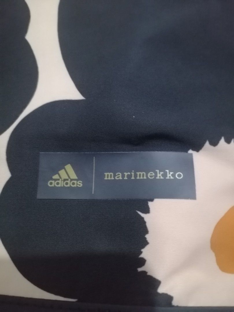 Adidas x Marimekko Print Backpack (Category: Backpacks) located in Manila. Submitted by alden_apparel (Listing ID 1467257059, Image 1). Description: - Authentic Adidas x Marimekko collaboration backpack - Eye-catching yellow, black, and beige flower print - Secure zip top closure with an adjustable back buckle strap - Comfortable dual shoulder straps and a convenient top handle - Co-branded logo patch on the front lower corner - Roomy main compar