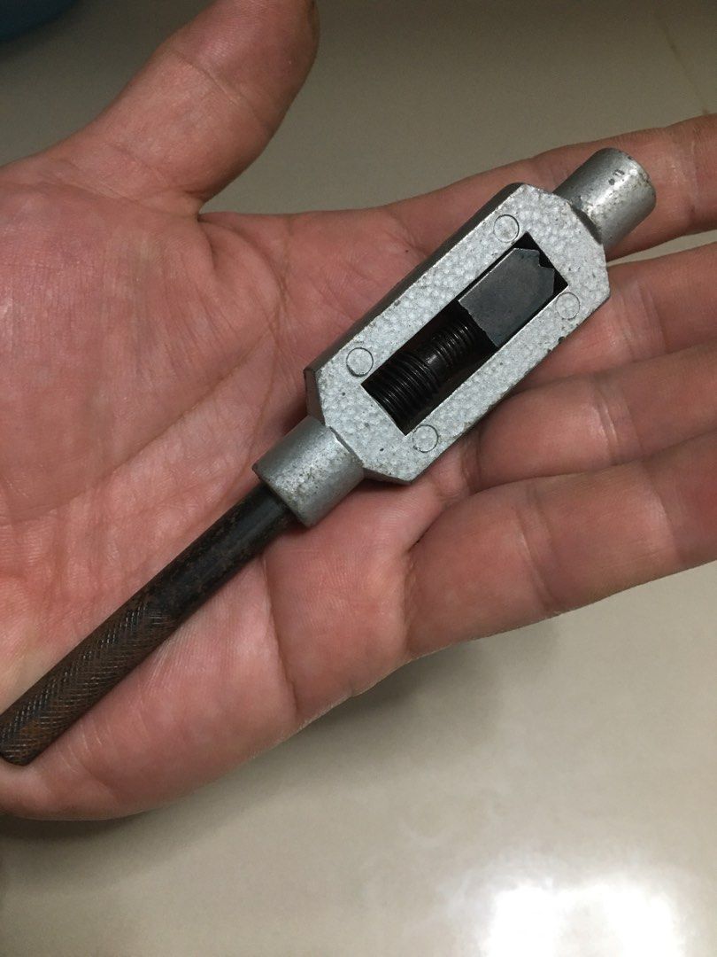 Adjustable T-Handle Tap Wrench Hand Tool (Category: Construction Tools & Equipment) located in Pasay City. Submitted by gilbertso62551 (Listing ID 1467195611, Image 2). Description: - Reliable handheld tap wrench for threading and tapping tasks - Silver like metal body equipped with adjustable jaws and removable jaw block - Includes a convenient sliding handle bar - Condition: Shows some rust on the handle and minor overall wear - Solid and fully