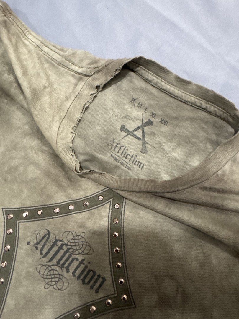Affliction (Category: Tshirts & Polo Shirts ) located in Bacoor. Submitted by 999archives_ (Listing ID 1467341921, Image 3). Description: vintage-style Affliction short-sleeve tie-dye t-shirt featuring a distressed green-brown wash, a central bedazzled (rhinestone-studded) fleur-de-lis graphic with the Affliction script logo, and raw/distressed hem details.