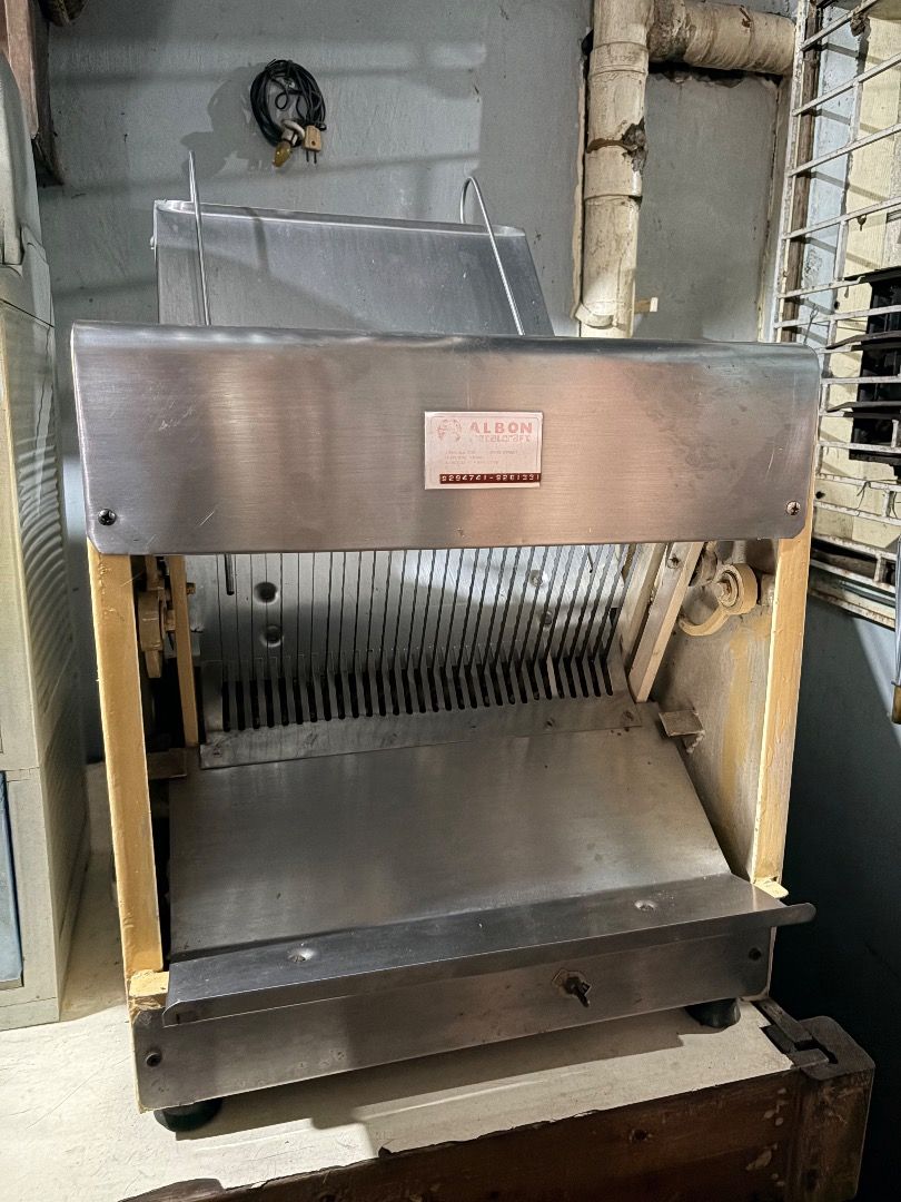 Albon Commercial Bread Slicer Machine (Category: Industrial Equipment) located in Quezon City. Submitted by officialfullcart (Listing ID 1467267507, Image 2). Description: - Brand/Model: Heavy-duty commercial bread slicer by Albon - Build: Stainless steel body and cutting blades with cream-colored side panels - Performance: Slices loaves evenly, quickly, and operates very smoothly - Condition: Fully functional, minor wear on exterior paint from c