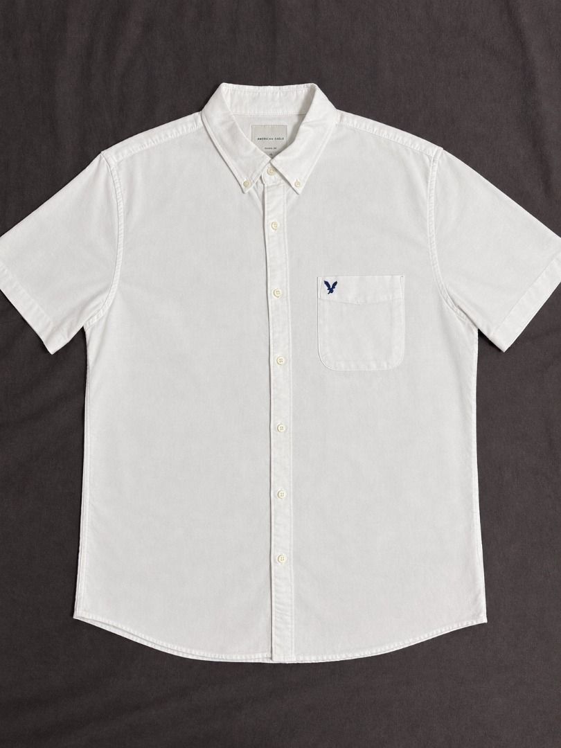 American Eagle Classic Fit White Button-Down Shirt Size L (Category: Tshirts & Polo Shirts ) located in Las Pinas. Submitted by luisanthonydelacruz (Listing ID 1467311057, Image 1). Description: American Eagle white button-down shirt in size Large. Features a classic fit, button-down collar, single chest pocket with embroidered eagle logo, and long sleeves. A versatile, clean wardrobe staple for any occasion..