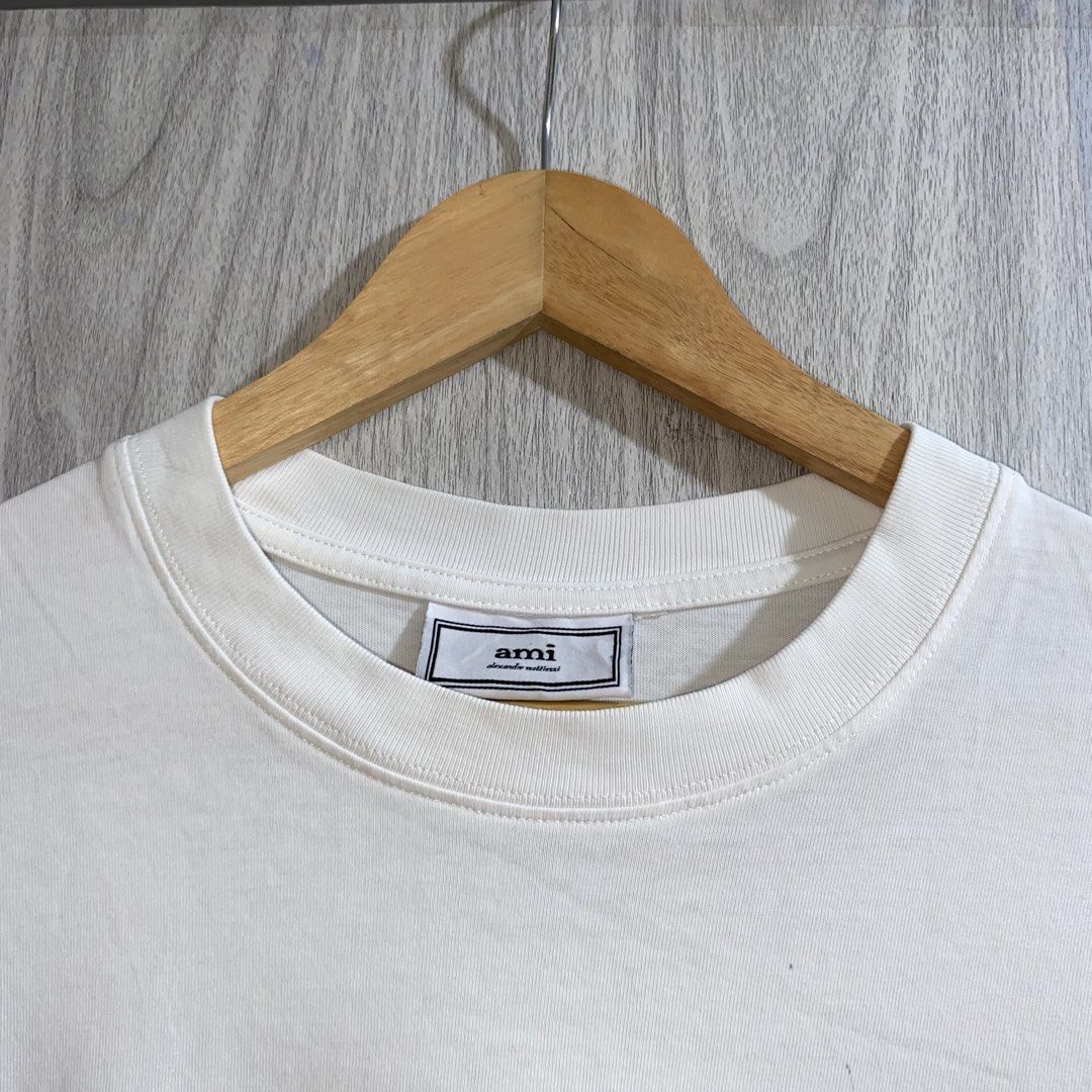 Ami Paris White Heart T-Shirt (Category: Shirts) located in Manila. Submitted by _thriftanddrip (Listing ID 1467276921, Image 3). Description: 22 x 27 Like new ₱700 White t-shirt from Ami Paris. Short sleeves with a ribbed crewneck collar. Features the signature black Ami de Coeur embroidered logo on the chest. Soft cotton fabric, clean styling. Regular fit, easy to match with daily outfits..