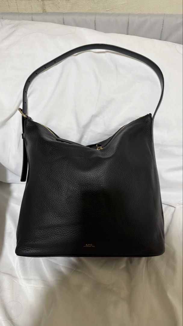 A.P.C. Black Leather Shoulder Bag (Category: Shoulder Bags) located in Pasig City. Submitted by ligayadelossantos0 (Listing ID 1467265806, Image 2). Description: - Brand: A.P.C. - Material: Premium black grained leather with gold hardware - Design: Minimalist everyday style with subtle logo stamp on front base - Closure: Double zip opening with leather pulls - Interior: Spacious main compartment - Strap: Adjustable strap attached with sturdy meta
