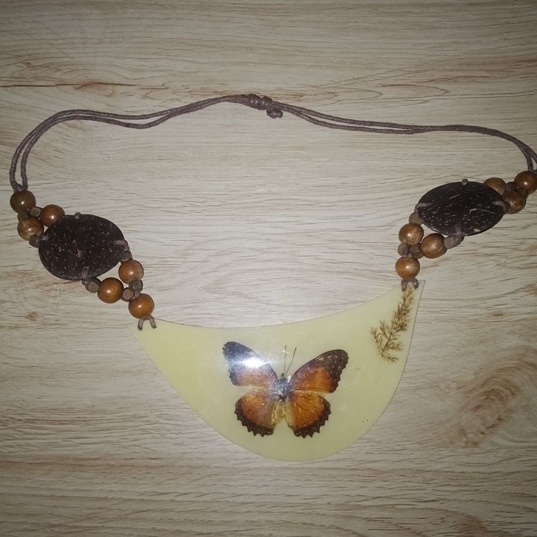 Assorted Statement and Beaded Necklaces Lot (Category: Necklaces) located in Quezon City. Submitted by macieee39997 (Listing ID 1467238903, Image 2). Description: - Bundle of statement necklaces sold as a set - Includes butterfly resin pendant, grey metallic beaded necklace with ribbon ties, blue and white shell disc necklace, and yellow rhinestone collar - Features various materials: wood, shell, resin, and glass beads - Perfect mix of styles to