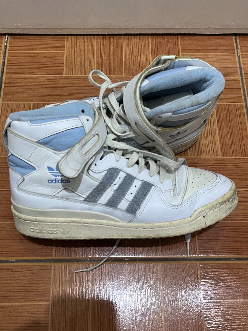 AUTHENTIC / ORIGINAL Adidas Forum Mid White Light Blue Sneakers (Category: Sneakers) located in Paranaque City. Submitted by strangers.things (Listing ID 1467313484, Image 2). Description: - Brand: Adidas Forum Mid - Color: White and Light Blue - Size: US 9 / UK 8.5 / EU 42 2/3 - Design: High-top with adjustable ankle straps, suede three stripes, and perforated toe box - Condition: Needs cleaning - Style: Perfect everyday streetwear kicks.
