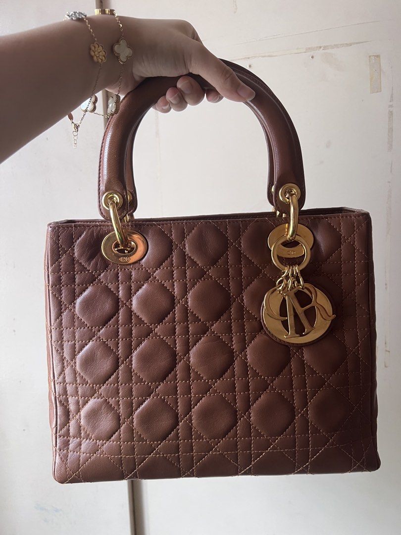 Authentic Christian Lady Dior Medium (Category: Luxury Bags & Wallets) located in Manila. Submitted by ot7purple (Listing ID 1467227043, Image 1). Description: - Authentic Vintage Christian Lady Dior in tan/brown lambskin leather - Iconic Cannage quilting with elegant gold-tone hardware and complete D.I.O.R charms - Zipper closure, code visible - Clean inside and out, has signs of usage - Inclusions: original 24k gold-plated strap and dust bag - 