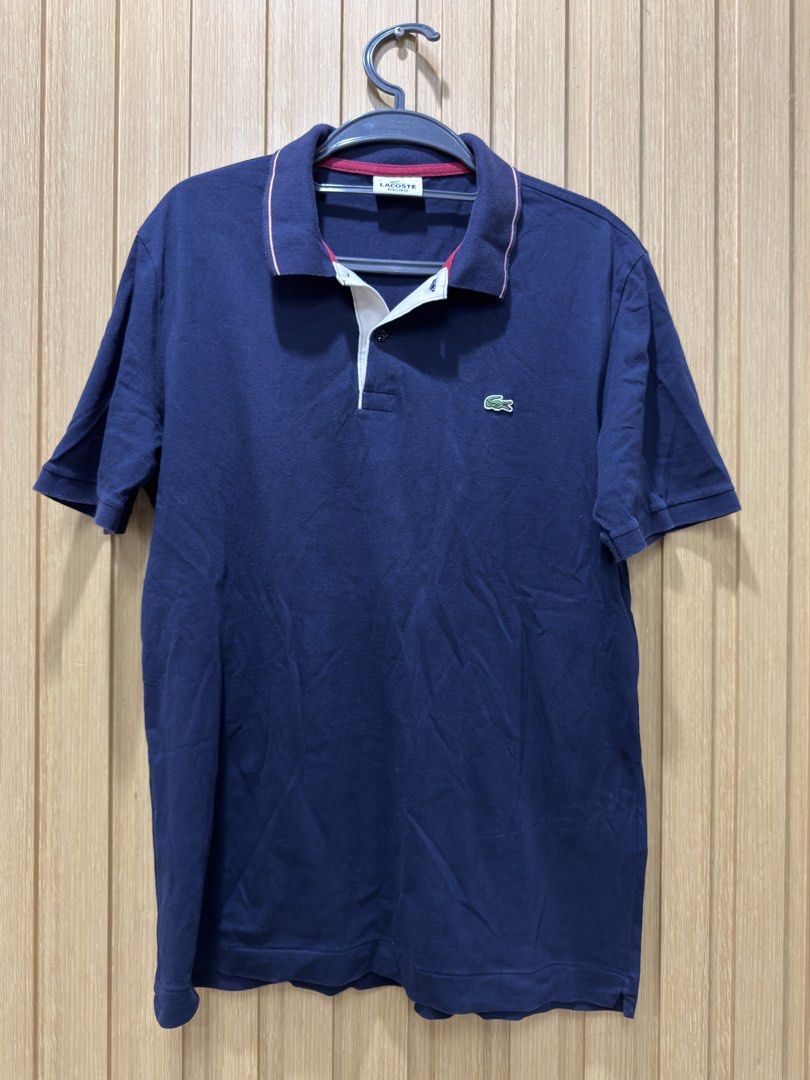 Authentic Lacoste Regular Fit Polo Shirt Navy Size 4 (Category: Tshirts & Polo Shirts ) located in Bacoor. Submitted by preloved_with_love_ (Listing ID 1467189795, Image 1). Description: - Brand: Lacoste - Color: Navy blue with red inner collar and white placket - Size: 4 (Regular Fit) - Measurements: 20 inches chest width, 27 inches length - Details: Signature embroidered green crocodile logo, button closure - Condition: Excellent, classic casua