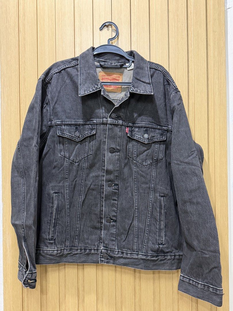 Authentic Levi's Black Denim Jacket Size L (Category: Coats, Jackets and Outerwear) located in Bacoor. Submitted by preloved_with_love_ (Listing ID 1467190086, Image 1). Description: Dimension: W-25 L-27 - Brand: Levi's - Style: Classic trucker jacket - Size: Large (L) - Color: Washed black with contrast stitching - Details: Button closure, front chest pockets, side welt pockets, iconic red tab, and leather inner patch - Material: Sturdy denim fa