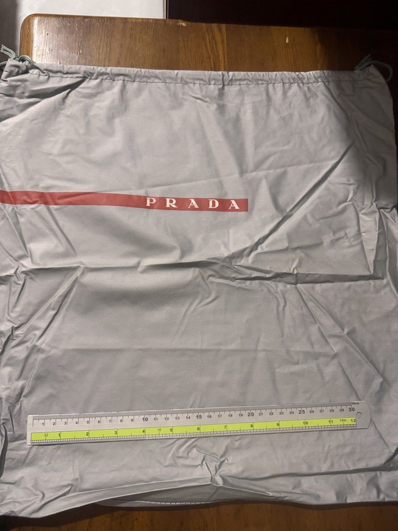 Authentic Prada Linea Rossa Grey Nylon Drawstring Dust Bag (16 × 17") (Category: Other Accessories) located in Tarlac. Submitted by itsri1988 (Listing ID 1467227512, Image 3). Description: Authentic Prada Linea Rossa Drawstring Dust Bag ✨ Keep your luxury items protected with this authentic industrial grey Prada dust bag featuring the iconic signature red logo stripe. Ideal for storing large designer handbags, backpacks, or luxury footwear. • Bra