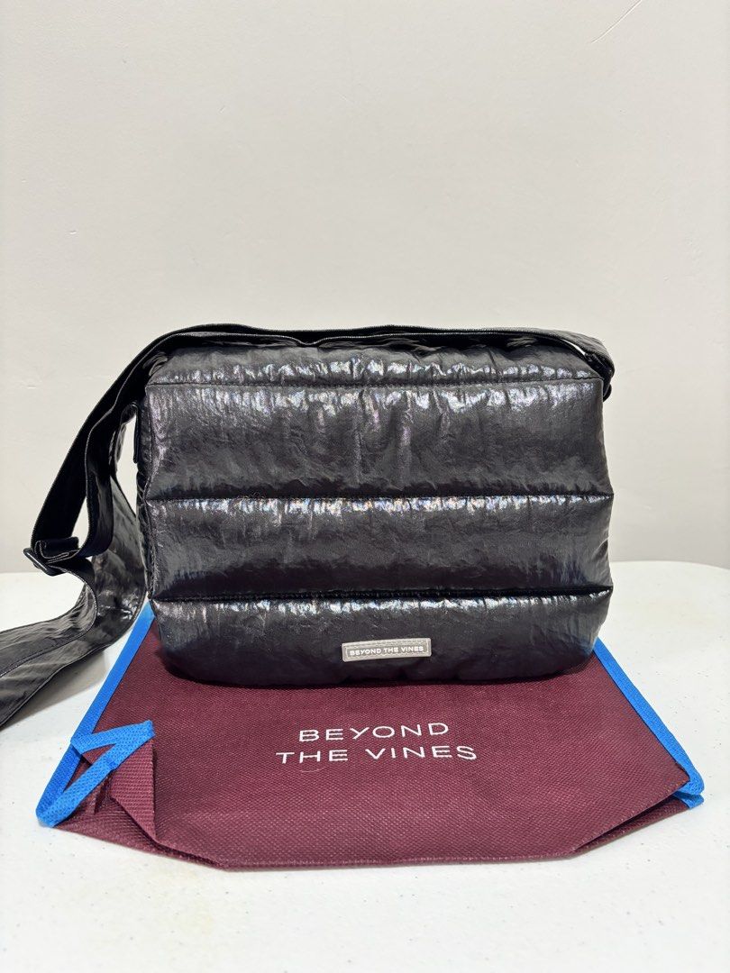 Beyond The Vines Glazed Poofy Bag - Black (Category: Cross-body Bags) located in Taguig. Submitted by yumi9121 (Listing ID 1467290946, Image 1). Description: Like new! 10/10 pristine condition RFS: Rarely used - Original Beyond The Vines Glazed Poofy Bag - Color: Black with contrast blue lining - Material: 100% textured coated nylon - Versatile design: Wear as a shoulder bag or crossbody with adjustable straps - Closure: Front flap with magnetic 