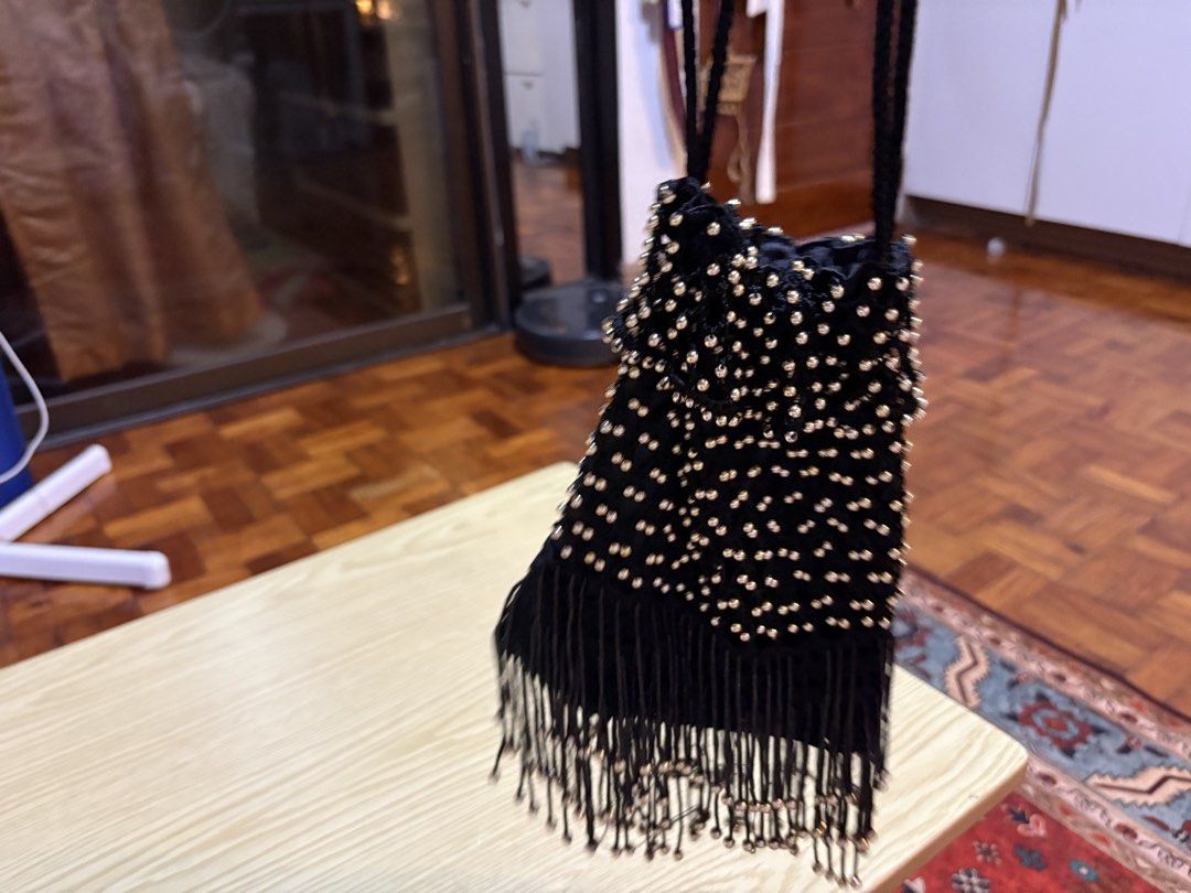 Black Beaded Fringe Evening Bag with Drawstring (Category: Shoulder Bags) located in Quezon City. Submitted by prelovedbybea (Listing ID 1467332886, Image 1). Description: - Color & Material: Black fabric covered in sparkling metallic gold beads - Design: Stylish drawstring closure with a playful long fringe hanging from the bottom - Strap: Comfortable long black braided strap for hands-free wear - Occasion: Ideal accessory for parties, night out