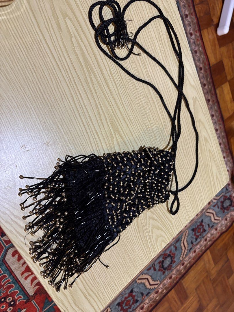 Black Beaded Fringe Evening Bag with Drawstring (Category: Shoulder Bags) located in Quezon City. Submitted by prelovedbybea (Listing ID 1467332886, Image 3). Description: - Color & Material: Black fabric covered in sparkling metallic gold beads - Design: Stylish drawstring closure with a playful long fringe hanging from the bottom - Strap: Comfortable long black braided strap for hands-free wear - Occasion: Ideal accessory for parties, night out