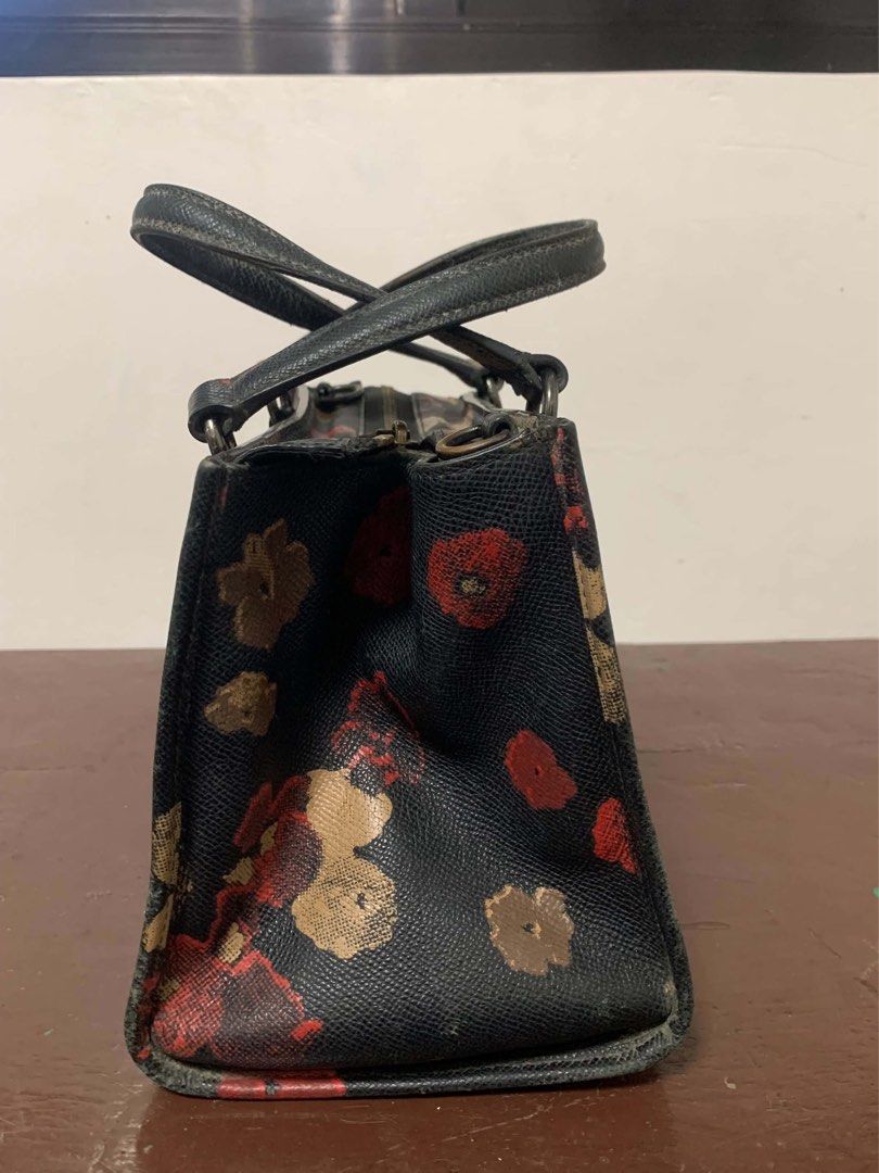 Black COACH Bag with strap (Genuine) (Category: Cross-body Bags) located in Borongan. Submitted by kabes_jane (Listing ID 1467191747, Image 3). Description: - Elegant black structured handbag with a vibrant red and gold floral pattern - Dual top handles secured with stylish metal hardware rings - Spacious double compartment design with secure top zip closure - Crafted from durable textured faux leather - Perfect everyday tote size for work, erran