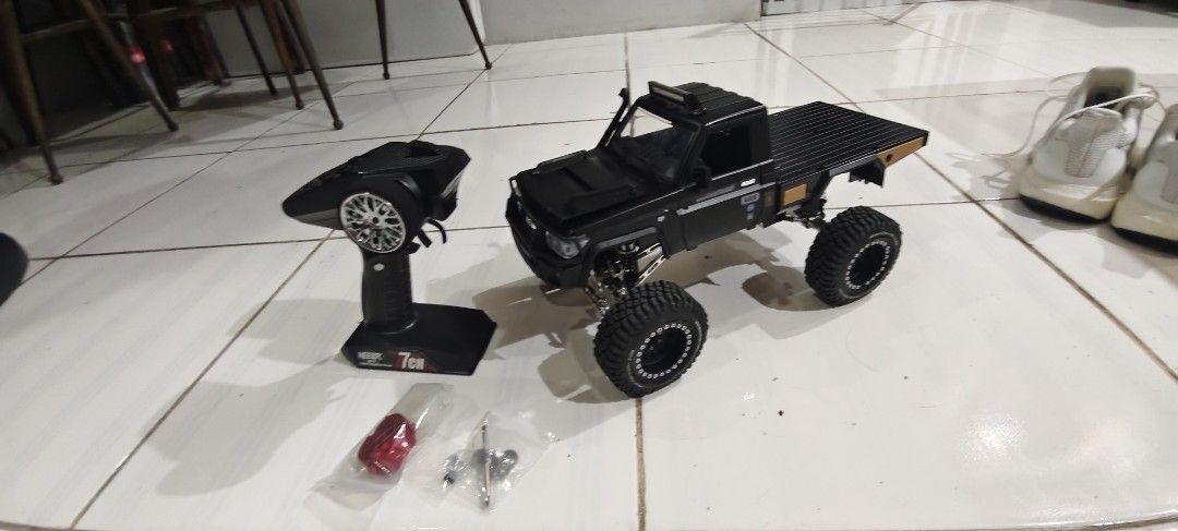 Black Land Cruiser RC Crawler 7CH Transmitter (Category: Remote Control Toys) located in Las Pinas. Submitted by jonjaymanese20 (Listing ID 1467247114, Image 1). Description: - Ready-to-run black Land Cruiser RC crawler truck - Includes 7-channel Neebrk remote controller and battery - Features durable metal links and axles underneath - Equipped with chunky off-road tires and scale details - Comes with extra metal upgrade parts, including a red ge