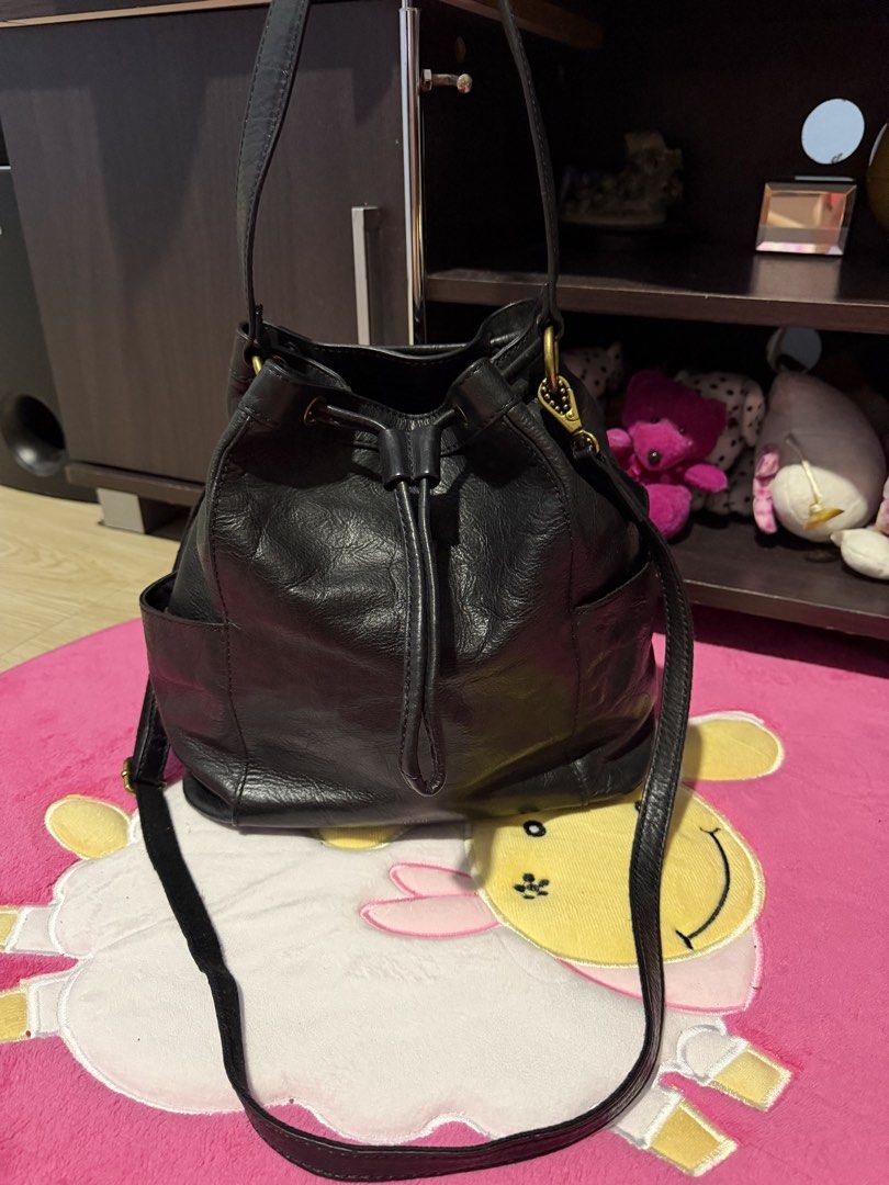 Black Leather Bucket Bag with Drawstring (Category: Cross-body Bags) located in Manila. Submitted by dapixphot28865 (Listing ID 1467191368, Image 1). Description: - Color/Material: Black soft textured leather - Closure: Front drawstring - Pockets: 2 side pockets for quick access - Carrying Options: Top handles and long shoulder strap - Hardware: Antique brass details.