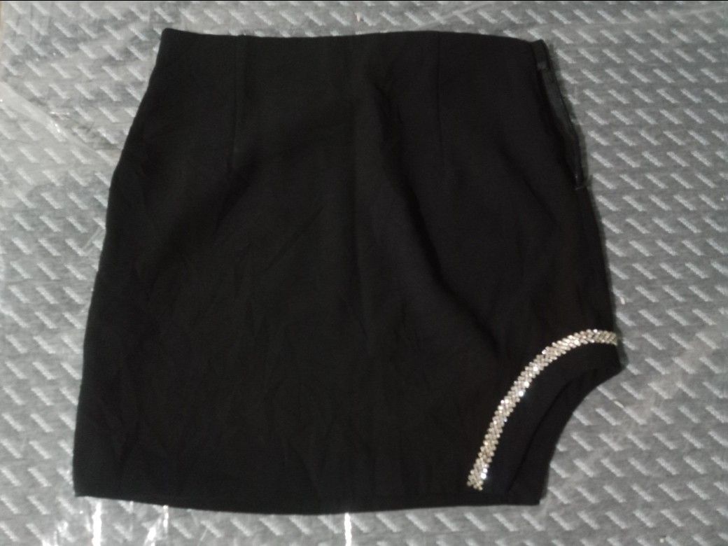 Black mini skirt with rhinestone trim slit (Category: Skirts) located in Manila. Submitted by swiftdolphin_f17535 (Listing ID 1467221637, Image 1). Description: - Color: Black - Style: High-waisted, bodycon mini skirt - Details: Asymmetrical hem with a dazzling rhinestone-embellished slit on the right side - Closure: Convenient side zipper - Material: Smooth, comfortable fabric - Occasion: Perfect for nights out, parties, and clubbing - Styling T