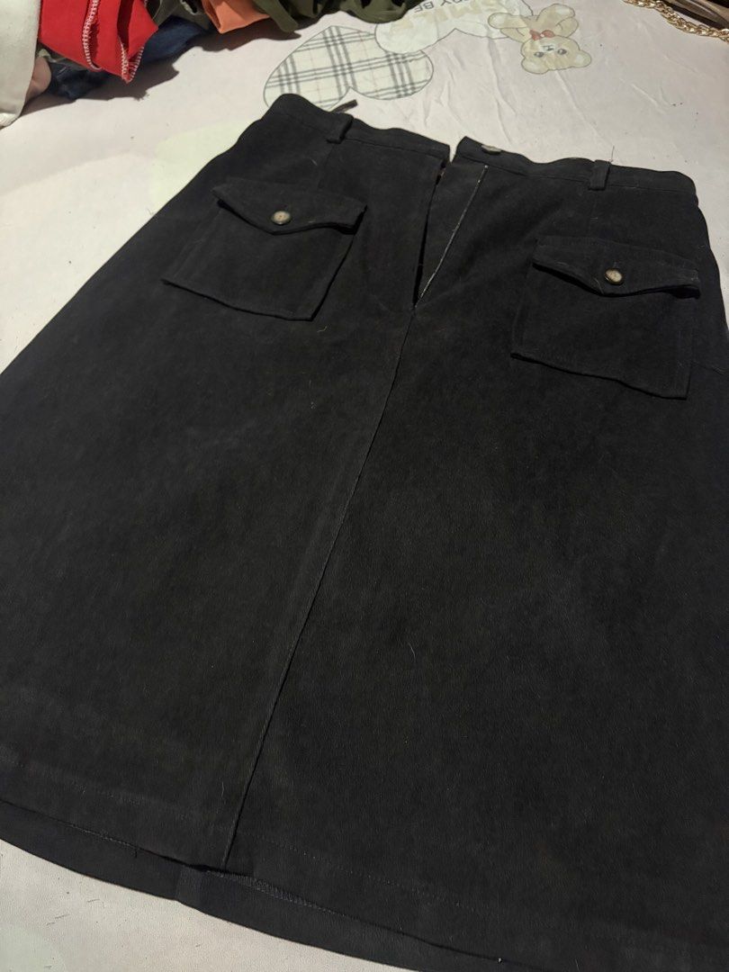 Black suede midi skirt size M with front pockets (Category: Skirts) located in Manila. Submitted by mcllts (Listing ID 1467344151, Image 3). Description: - Color: Black - Length: Midi - Material: Soft suede fabric with full lining - Size: M - Features: Structured waistband with belt loops, front button-flap utility pockets, and centered vertical front seam - Condition: Excellent NOTE: You can buy 2 other items and get 5% discounts.