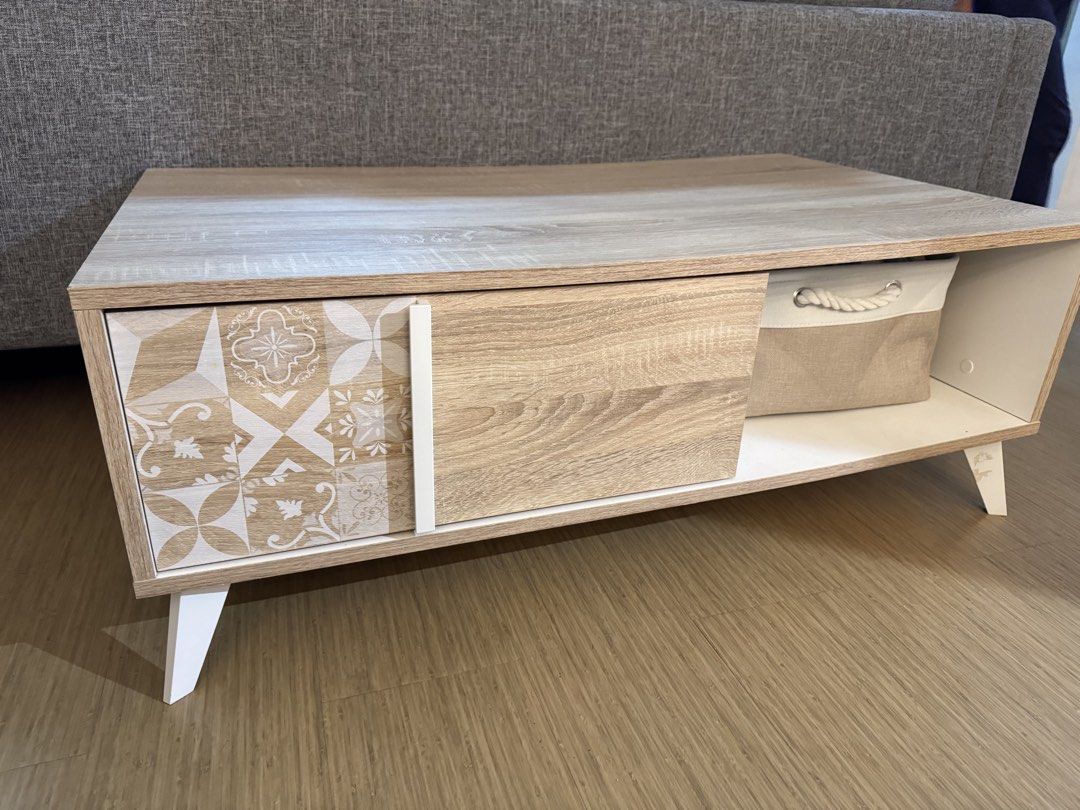 Blims Fine Furniture Center Table (Category: Tables & Sets) located in Calamba. Submitted by cheriiv (Listing ID 1467183249, Image 2). Description: - Modern wooden coffee table with stylish white slanted doors - Features 1 sliding wooden door and 1 patterned tile-design door section - Includes an open shelf - Beautiful light wood grain top surface.