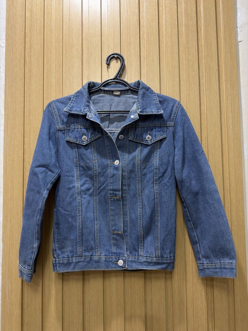 Blue Denim Jacket Size M (Category: Coats, Jackets and Outerwear) located in Bacoor. Submitted by preloved_with_love_ (Listing ID 1467334174, Image 1). Description: - Style: Classic blue denim jacket - Fit/Size: Medium (tag inside collar, exact measurements on label) - Details: Contrast stitching, metal button closures, two chest flap pockets - Material: Durable cotton denim - Versatility: Perfect for layering in any season.