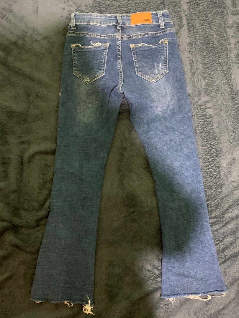 Blue Distressed Flare Jeans with Raw Hem (Category: Jeans) located in Manila. Submitted by quishi061210 (Listing ID 1467202928, Image 2). Description: - Style: Mid-rise flare jeans in a vintage medium wash - Details: Trendy distressed accents on the front and back pockets - Hem: Cool raw, frayed hem at the ankles - Design: Classic five-pocket layout with button and zip fly - Finishing touches: Contrast stitching and a brown leather back patch.