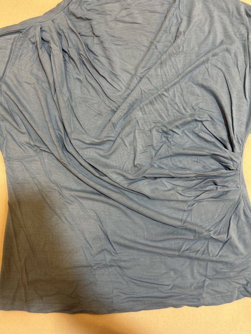 Blue draped asymmetrical sleeveless top (Category: Sleeveless) located in Quezon City. Submitted by kyokoaman (Listing ID 1467308205, Image 3). Description: - Color: Dusty blue - Material: Soft and stretchy lightweight jersey - Design: Draped cowl neckline with side gathering and asymmetrical hem - Styling: Perfect for layering or wearing solo with jeans and skirts.